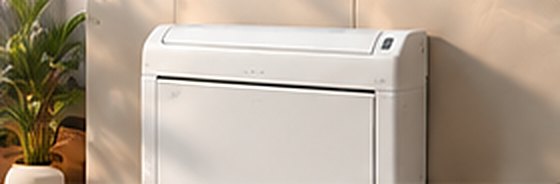 Wit vloer- of consolemodel airco naast een plant